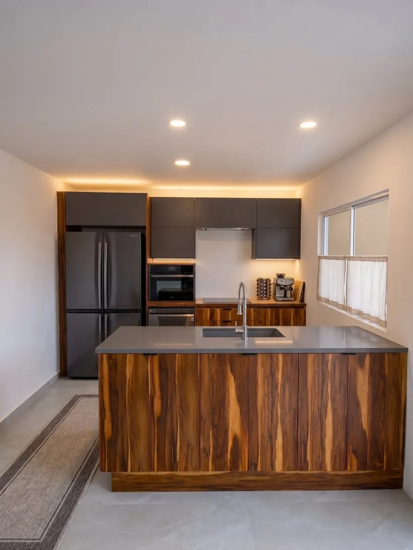 Cocina integral terminada con isla de madera e iluminación integrada en Tijuana