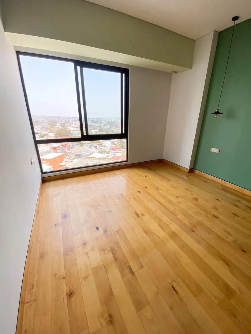 Piso de madera instalado en recámara con ventanal en Tijuana