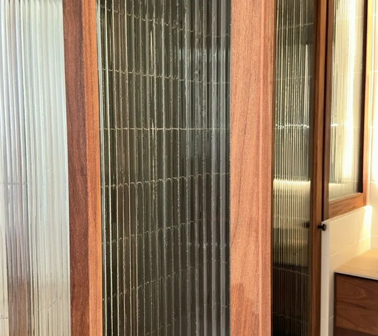 Puerta corrediza de cristal estriado con marco de madera parota en Tijuana