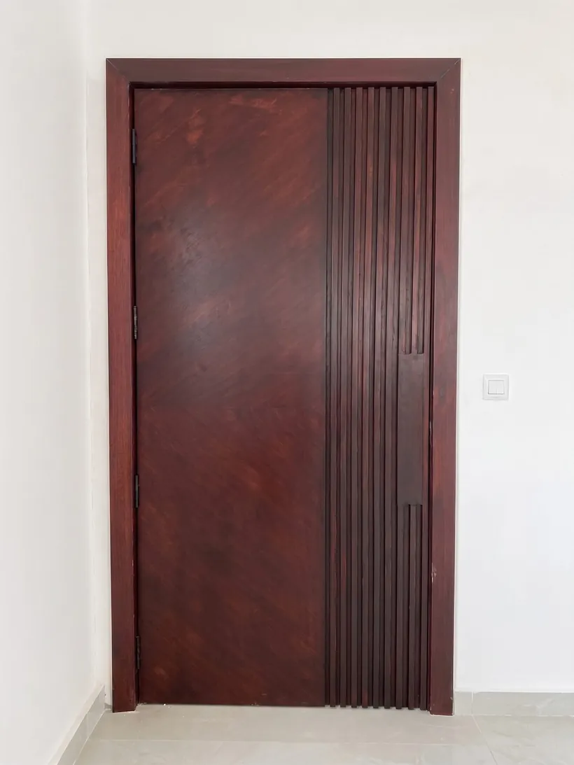 Puerta pivotante de madera con tablilla vertical fabricada a la medida en Tijuana