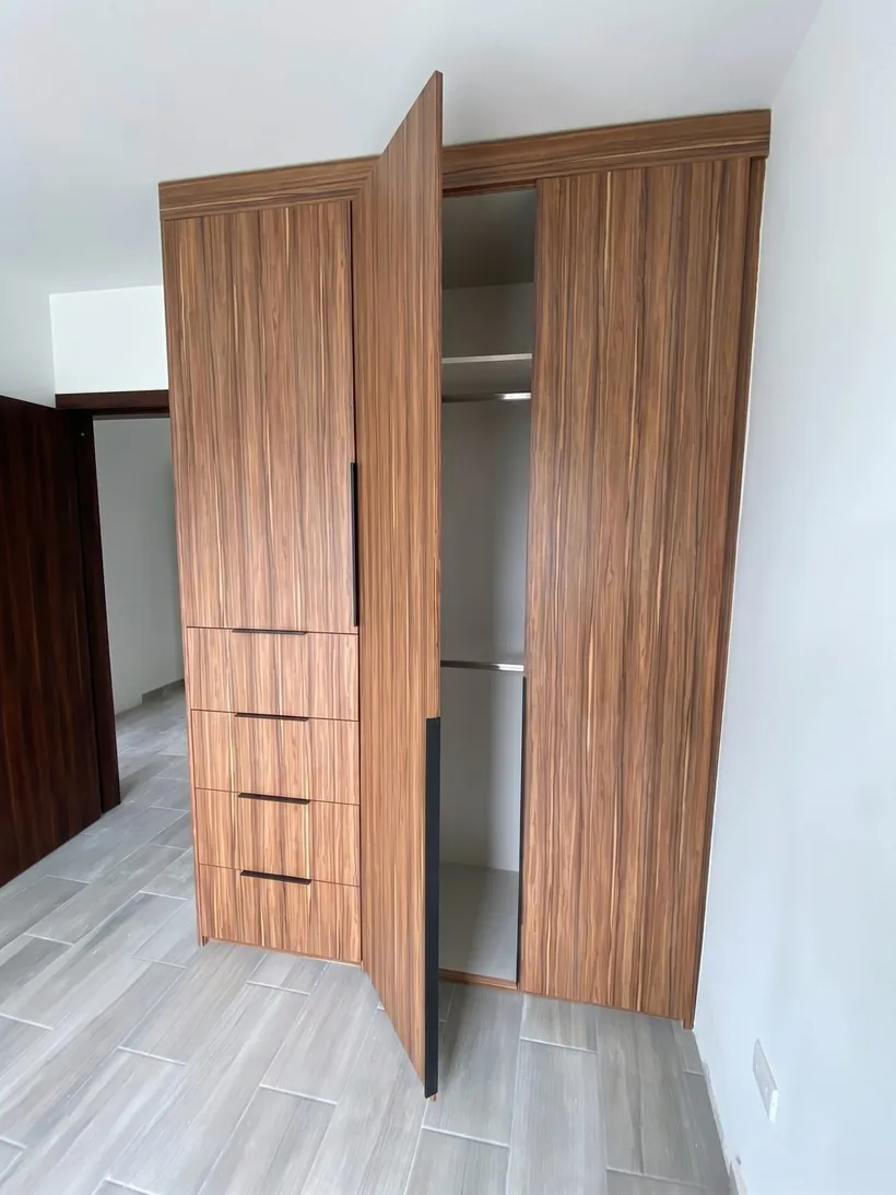 Armario de tablilla con las puertas abiertas, mostrando tubos y entrepaños interiores
