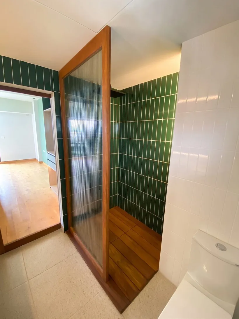 Regadera con cancel de cristal estriado vista desde el interior del baño