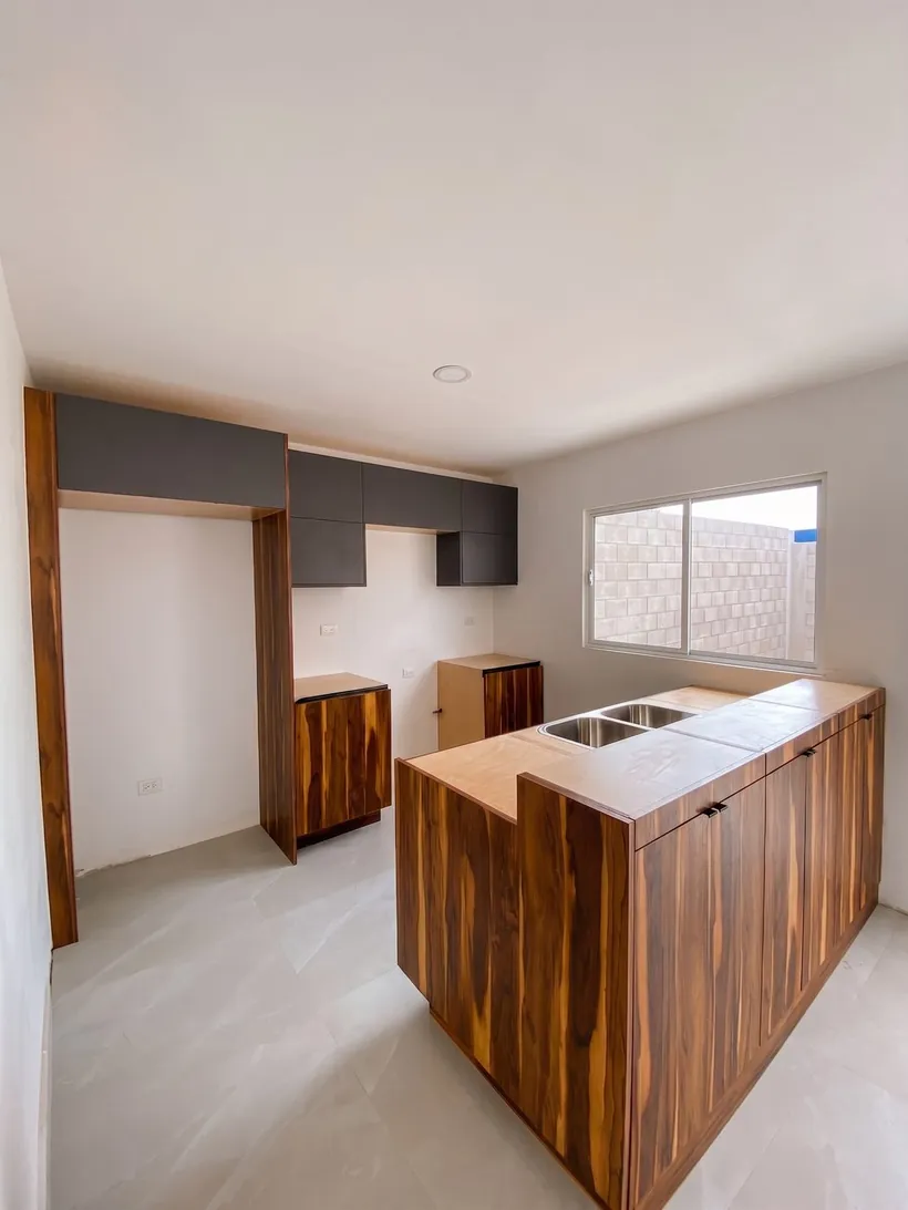 Cocina en L con isla de madera y ventana