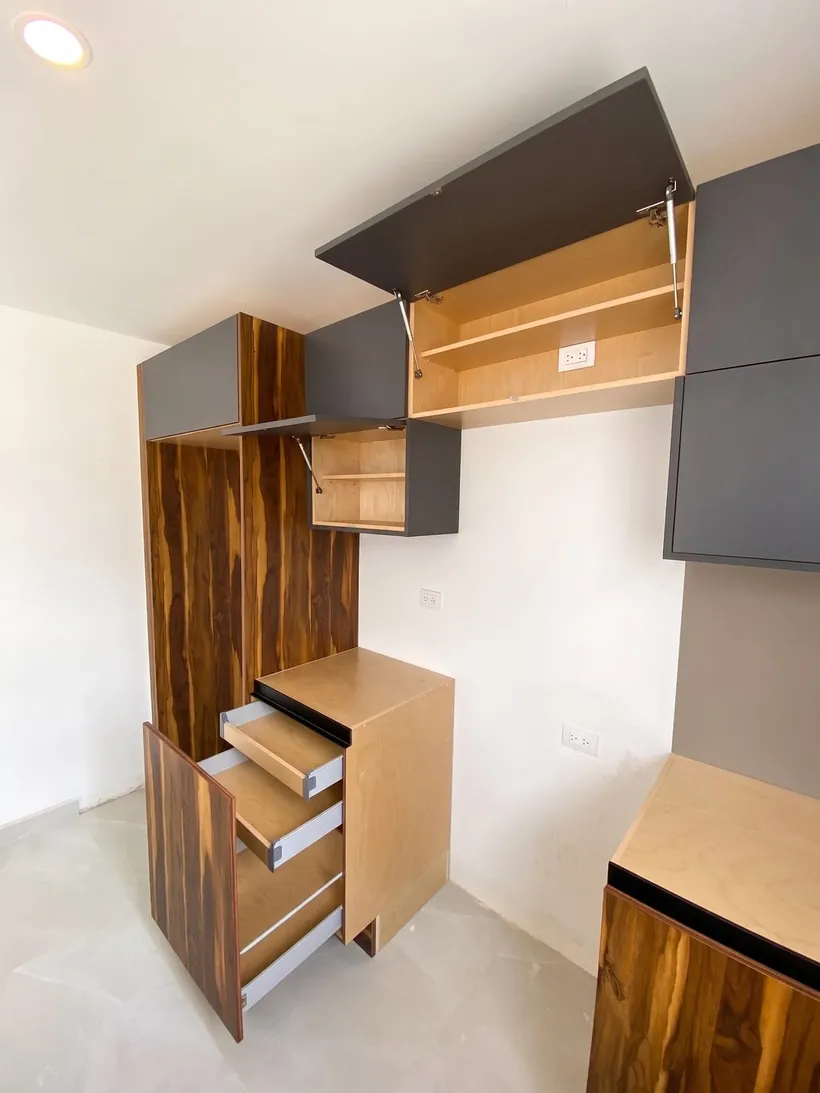 Alacena de piso a techo con puertas abatibles y cajones abiertos